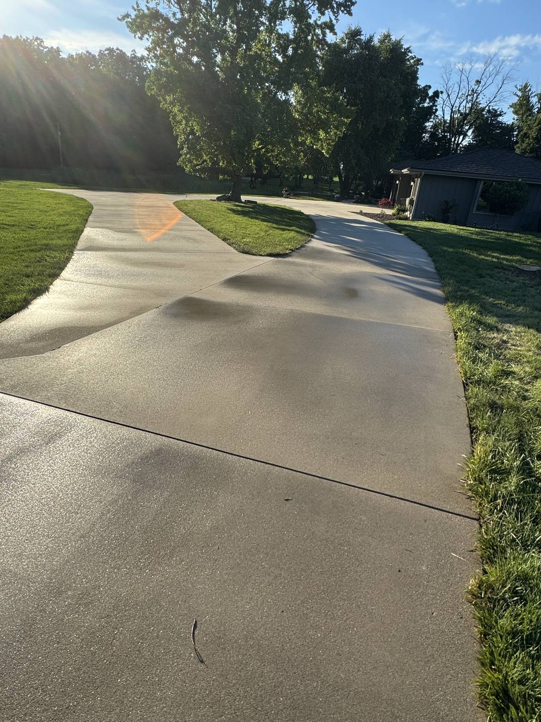 Clean residential concrete driveway in morning light