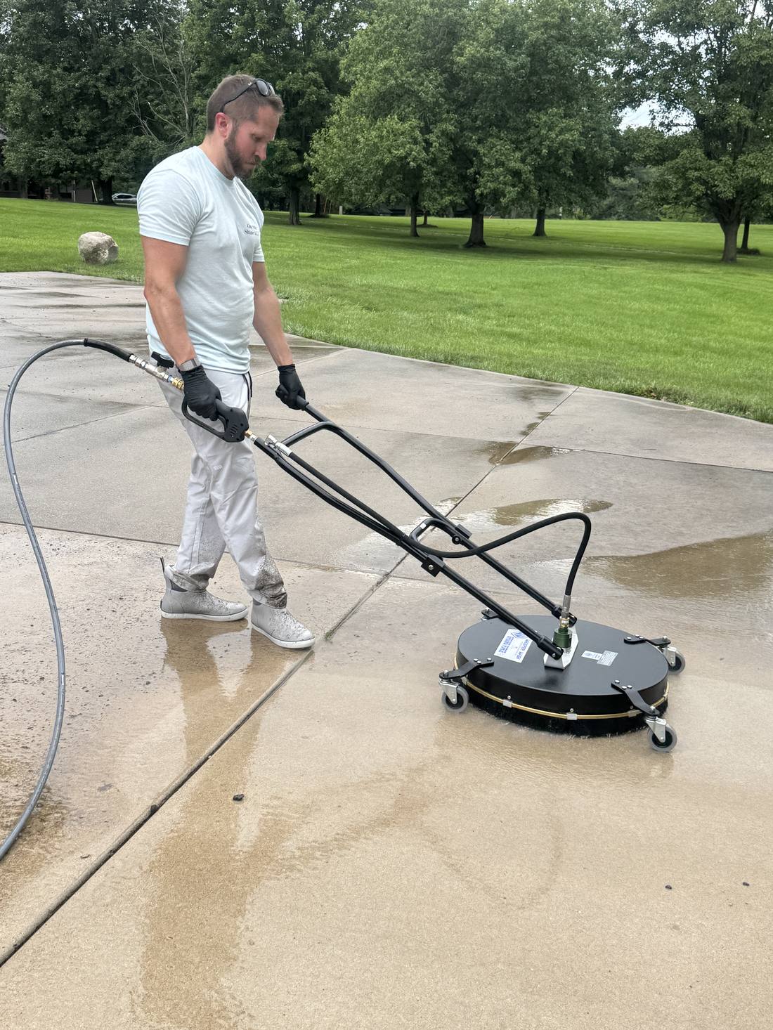 Professional surface cleaner being used on a concrete driveway