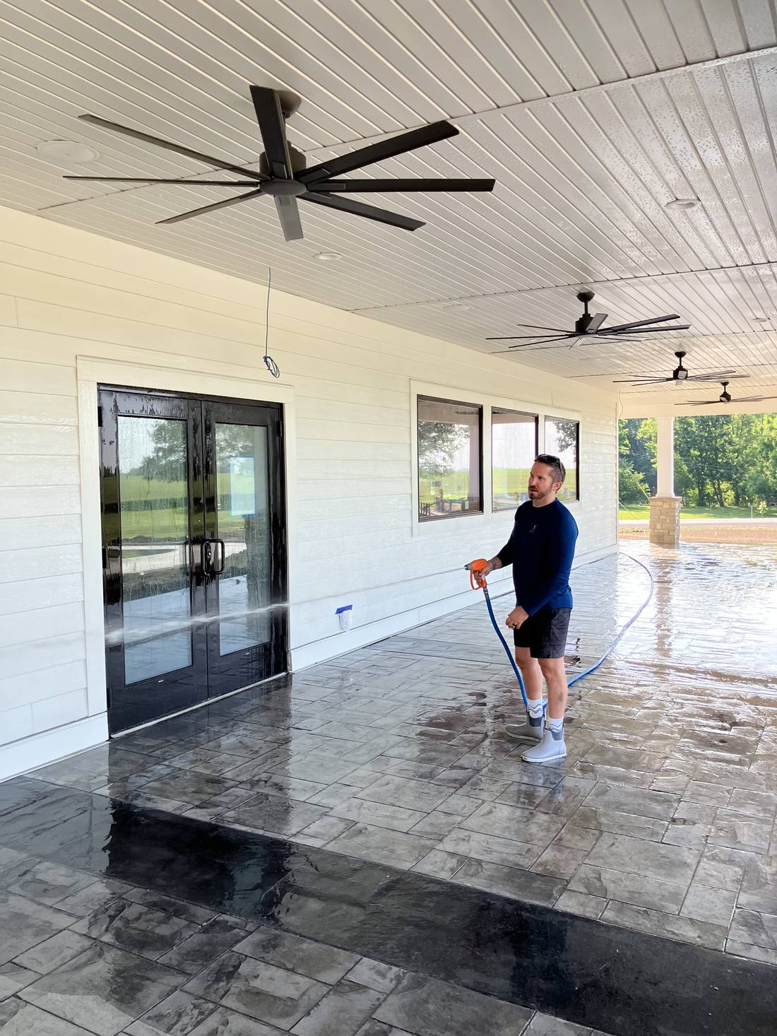 Covered stamped concrete patio being cleaned at a commercial property