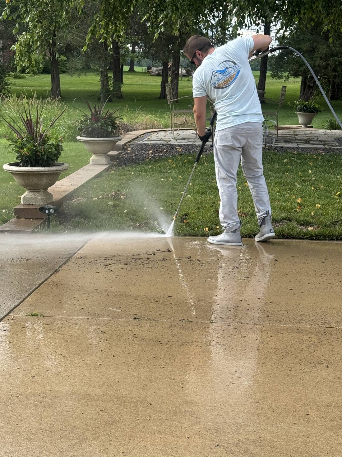 On-Site Shine pressure washing a concrete walkway in Central Illinois, showing the clean surface next to the untouched area